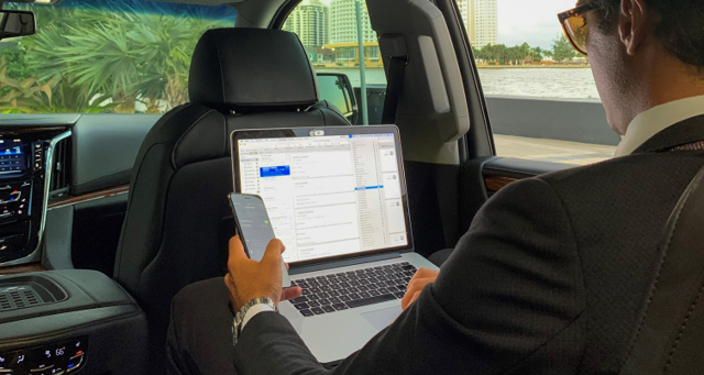 A businessman working on his laptop in a limo.